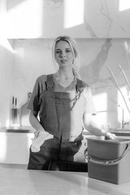 A professional cleaning team from Edgware Cleaner engaged in surface cleaning and deep cleaning in a modern living room. The team, consisting of three people, is equipped with vacuum cleaners, mops, a